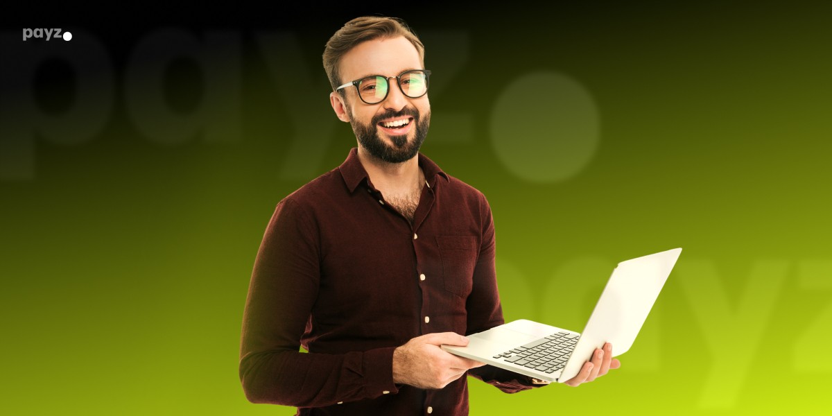 imagem mostra homem sorrindo ao utilizar um notebook
