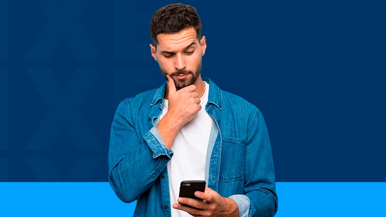 Imagem mostra homem pensativo com um smartphone na mão