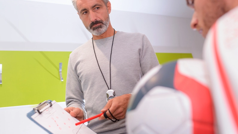 Imagem mostra um técnico de futebol em campo