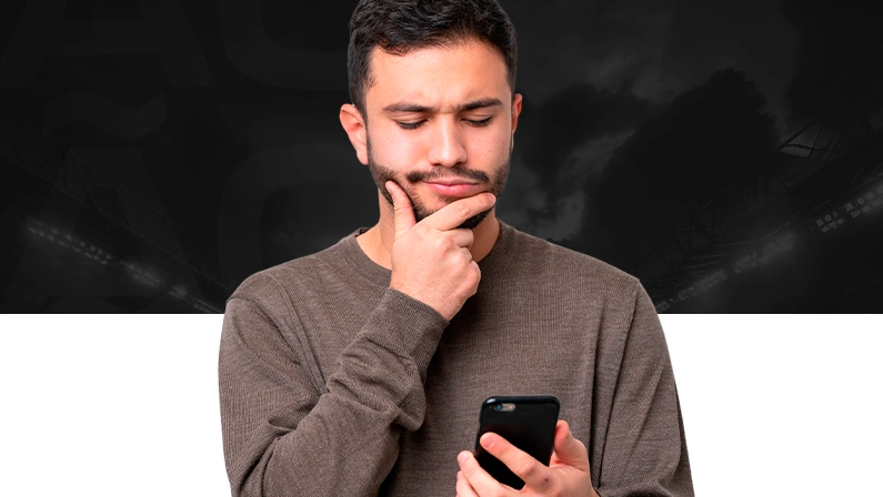 Imagem mostra homem pensativo utilizando um smartphone