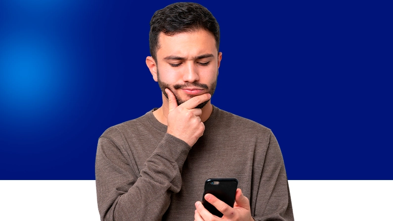 Imagem mostra homem pensativo ao utilizar um smartphone