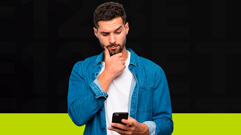 Imagem mostra homem pensativo utilizando um smartphone