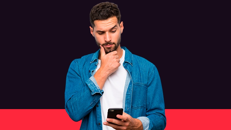Imagem mostra homem pensativo utilizando um celular