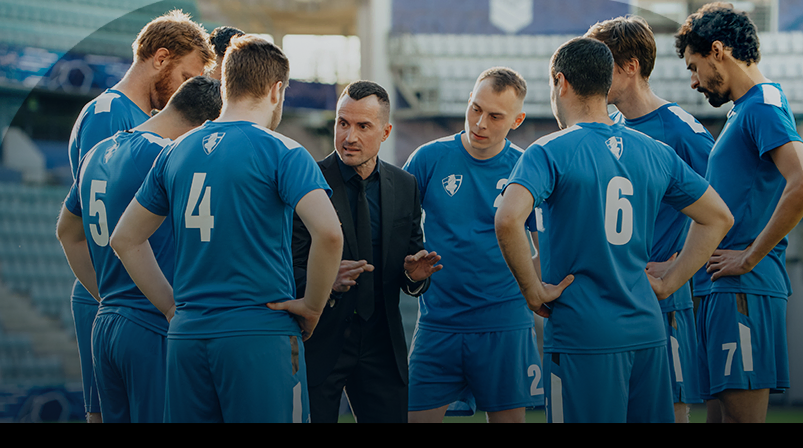 Imagem mostra técnico conversando com jogadores de futebol
