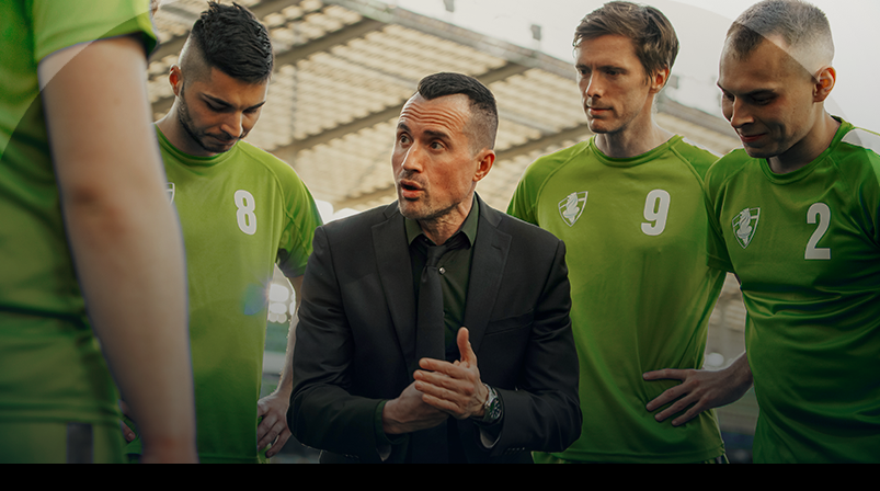 Imagem mostra técnico conversando com jogadores de futebol