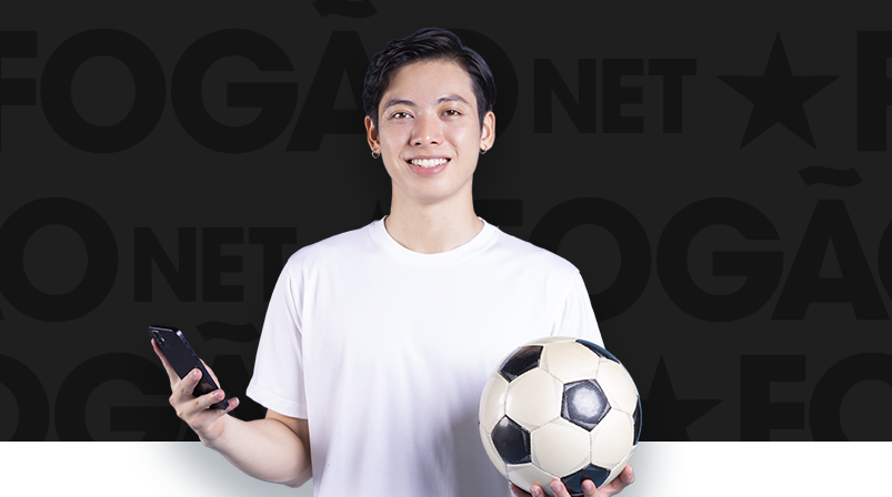 Imagem mostra homem sorrindo ao segurar um celular e uma bola de futebol