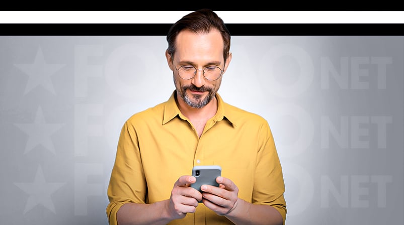 Imagem mostra pessoa sorrindo ao utilizar um smartphone